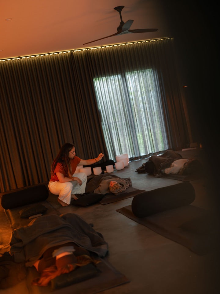 Jess guiding participants resting on mats
