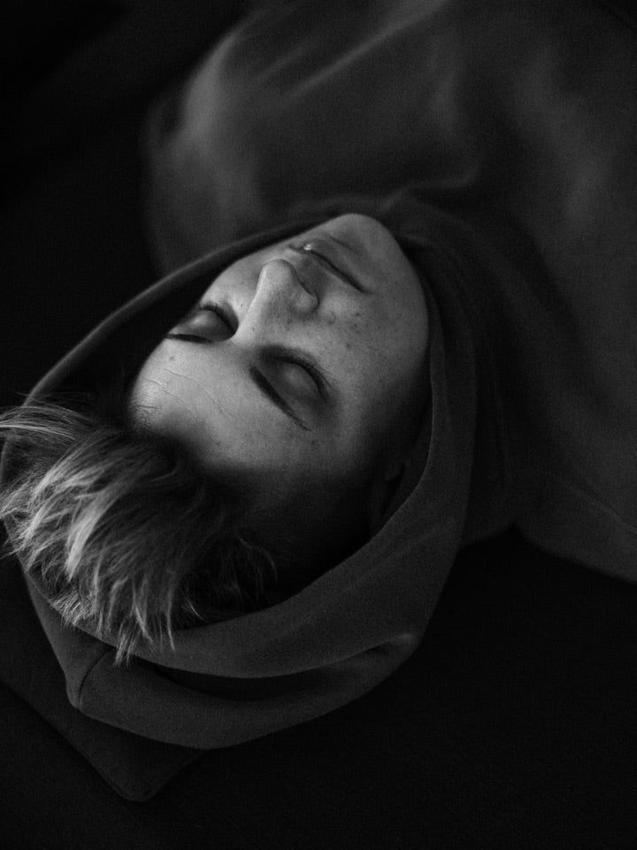 A participant resting during a group experience, photographed in black and white
