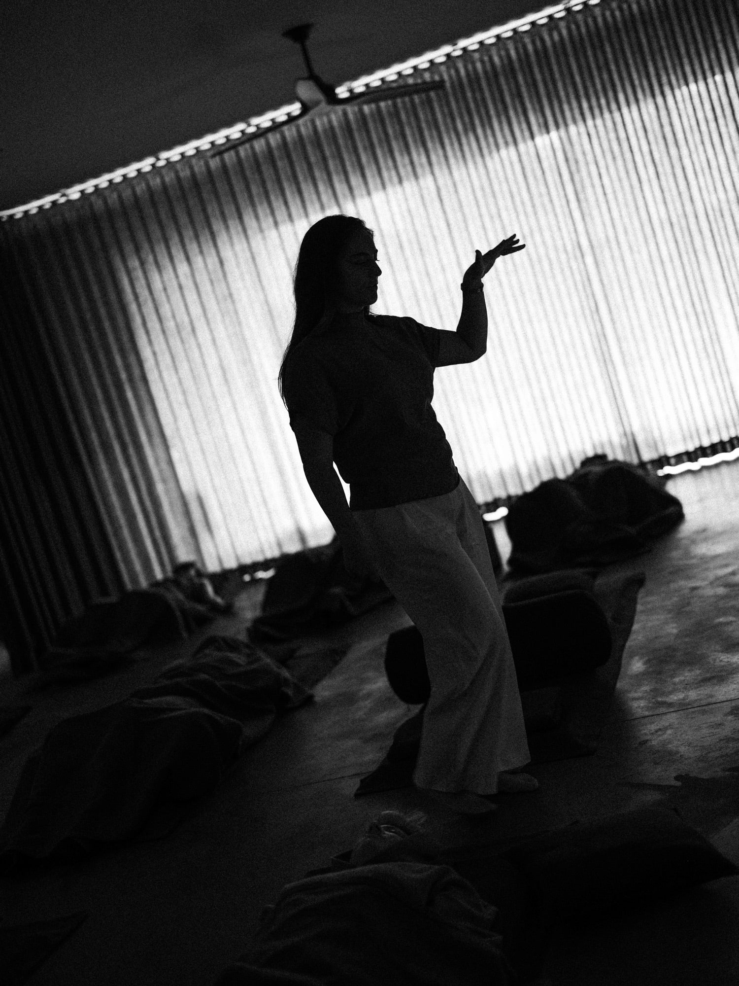 Jess standing as she guides a group experience, photographed in black and white