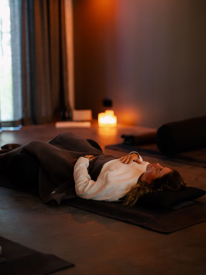 Participants resting in the candlelit studio